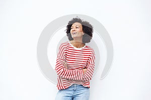 Happy older woman laughing with arms crossed against white background