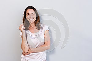 Happy older woman standing against white background