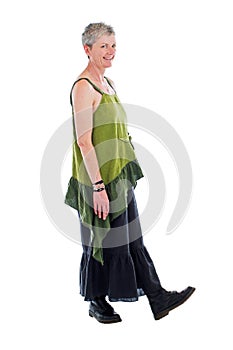 Happy older woman stands in flowing long dress