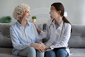 Happy older woman talking with friendly doctor during visit
