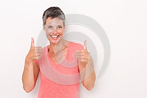 Happy older woman with thumbs up against white background