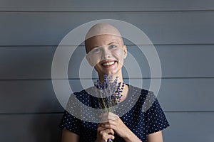Happy oncology patient holding bunch of wild flowers