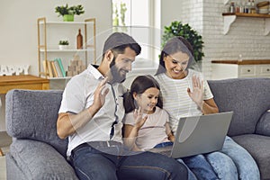 Happy online family uses laptop at home.