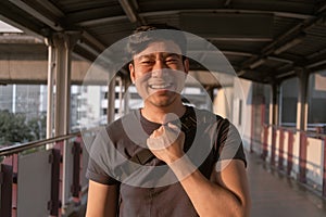 Happy ordinary man walk on the sky-train platform in Bangkok.