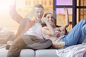 Happy  couple soulmate watching sport match on tv-set