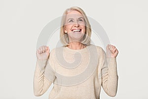 Happy overjoyed middle aged woman celebrating win isolated on background