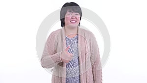 Happy overweight Asian woman giving thumbs up ready for winter