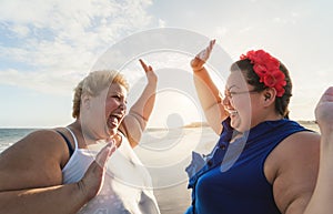 Happy overweight women having fun on tropical beach