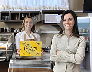 Happy owner of a cafe showing open sign photo