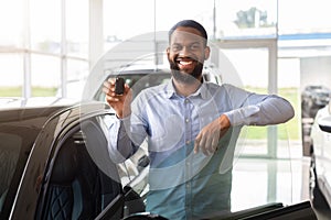 Happy Owner. Cheerful Black Man Standing Near New Car And Holding Keys