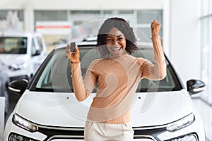 Happy Owner. Overjoyed Black Lady Holding Keys Of New Car After Buying