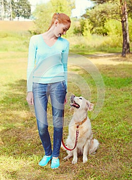 Happy owner woman and Golden Retriever dog walking