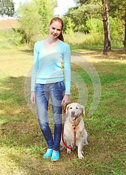 Happy owner woman and Golden Retriever dog walking in summer