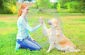 Contento il proprietario una donna formazione d'oro il cane sul erba 