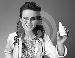 Happy paediatrician doctor showing nasal drops on