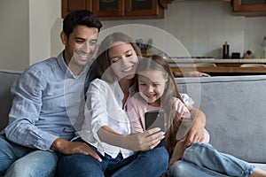 Happy parents and cheerful daughter kid talking on video call