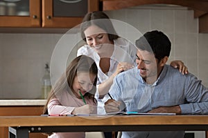 Happy parents and cheerful kid girl drawing in colored pencils
