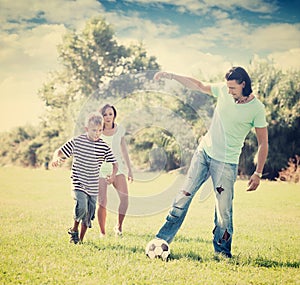 Happy parents with child playing with ball