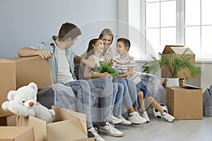 Happy parents and children having fun in their new house or apartment on moving day