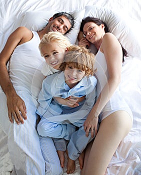 Happy parents and children together on bed