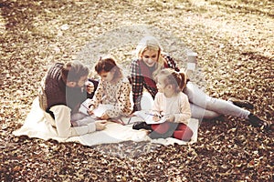 Happy parents with daughter in park and writing together