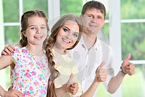 Happy parents and daughter posing in room photo