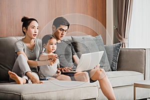 Happy parents with daughter using laptop