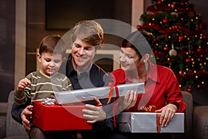 Happy parents giving christmas gifts to son