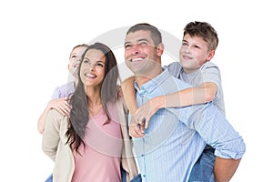 Happy parents giving piggyback ride to children while looking up