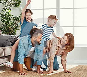 Happy parents giving piggyback ride to kids at home