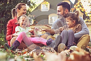 Happy parents have play with children outside. Autumn season.