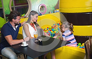 Happy parents having fun with kids in children playground