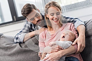 happy parents holding ther little yawning