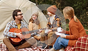 Happy parents and kids enjoying great family camping trip in nature