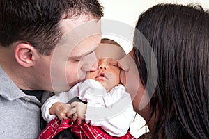 Happy Parents Kiss Their Newborn