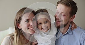 Happy parents and little daughter close up portrait