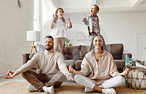 Happy parents  meditating in room with playful kids