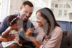 Happy parents playing with baby girl on dadÃ¯Â¿Â½s knee, close-up