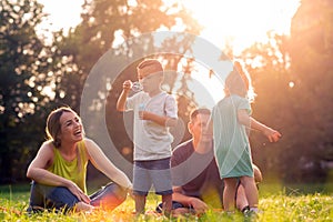 Happy parents playing with children outside