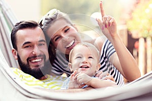 Happy parents playing with their baby boy in hammock