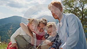 Happy parents posing children sitting meadow sunny day closeup. Family holiday.