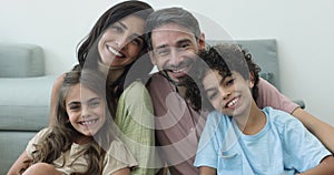 Happy parents and sibling girl and boy posing for portrait