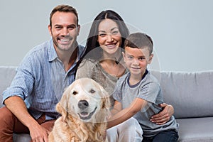 Happy parents with son and pet in living room