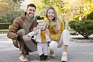 Happy parents with their baby in park on sunny day