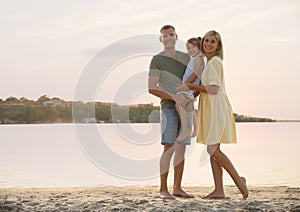 Happy parents with their child on beach, space for text. Spending time in nature