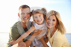 Happy parents with their child on beach. Spending time in nature