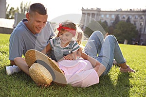 Happy parents with their child having fun on green grass. Spending time in nature