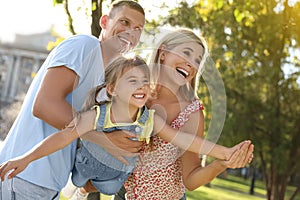 Happy parents with their child having fun outdoors. Spending time in nature