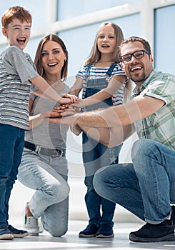 Happy parents and their children built a tower out of their hands