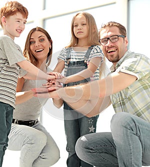 Happy parents and their children built a tower out of their hands